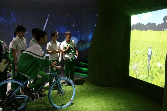 海口旅游职业学校的学生，体验虚拟现实技术的骑行。 图/视觉中国