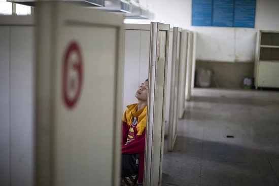  山东某技校焊接专业课间，学生靠在隔板间休息。图/视觉中国