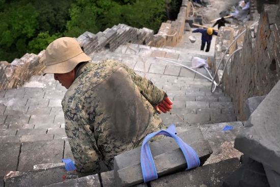 　　2017年5月3日，箭扣长城修缮工地，一名工人刚刚完成一次搬运，其衣服上留下和城砖形状一样的印记。