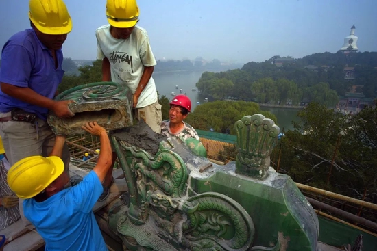 　2012年8月26日，北海公园团城，工作人员安装承光殿正脊两端兽吻琉璃构件。