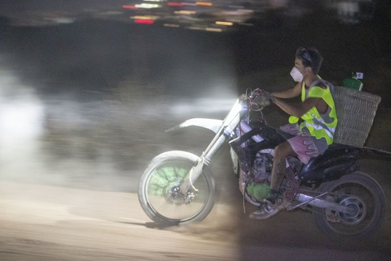 　　图说：8月25日晚，在重庆市北碚区缙云山，志愿者骑摩托车往山上运送灭火救援物资。新华社记者 黄伟 摄