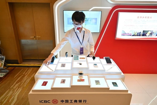 9月8日，在2022中国（北京）数字金融论坛设置的数字人民币体验区，工商银行展台的工作人员摆放数字人民币硬钱包产品。新华社记者 李鑫 摄