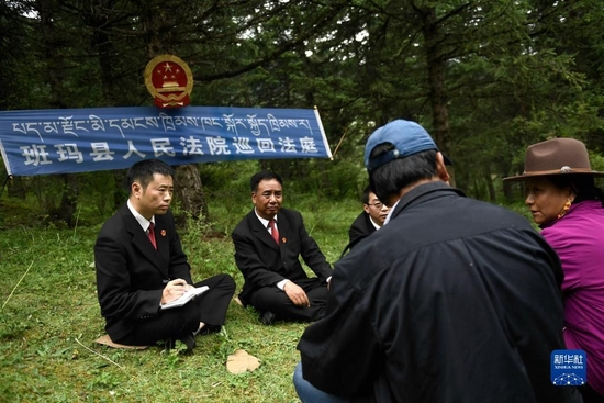 青海省果洛藏族自治州班玛县人民法院工作人员在解答当地牧民群众的法律咨询（2021年8月7日摄）。班玛县地处高原，山大沟深，群众居住分散。近年来，班玛县人民法院深入各乡镇，将巡回法庭搬到森林、草原，在牧民家门口提供诉讼服务，还通过以案说法、模拟法庭等形式，开展法律咨询、法治宣传。新华社记者 张龙 摄