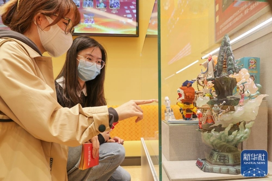 10月10日，观众在“奋进新时代”主题成就展第五单元“坚定文化自信 建设社会主义文化强国”展厅内观看电影相关的文化产品。新华社记者 张玉薇 摄