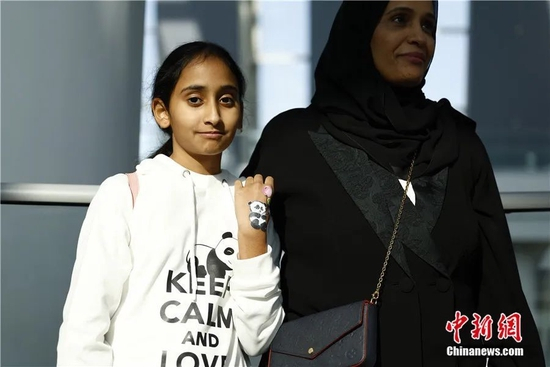  一名女孩展示在手背上绘制的大熊猫。11月17日，在世界杯开赛前夕，首对中国赴卡塔尔大熊猫“京京”与“四海”正式与当地民众见面。富田 摄