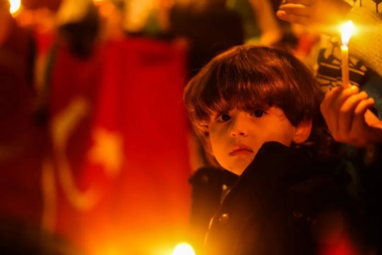 2月7日，在加沙地带汗尤尼斯，一名儿童手拿蜡烛悼念地震遇难者。新华社发（亚西尔摄）