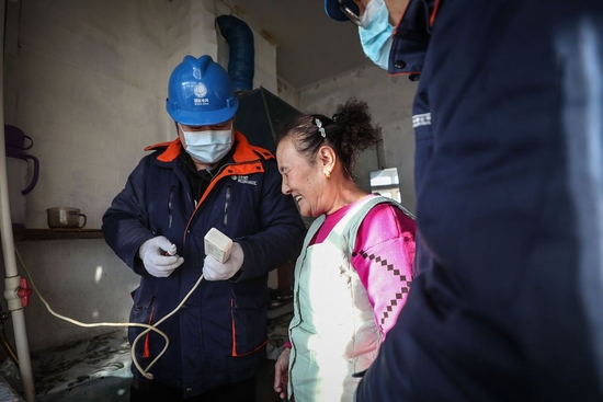  郭家供电所员工在“盲人大院”叮嘱盲人居民安全使用插排。（新华社记者 潘昱龙摄）