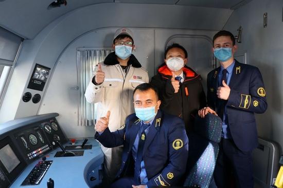 这是中国电力机车出口乌兹别克斯坦，中方技术人员和乌方驾驶人员的合影。