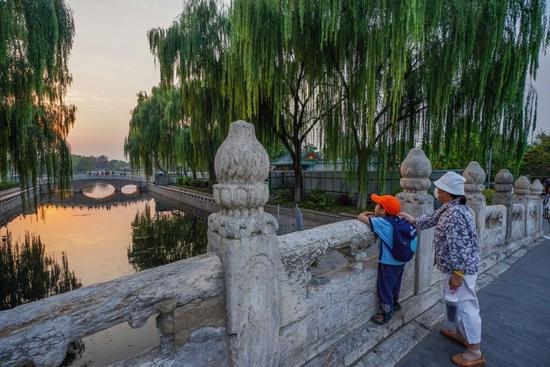 市民在京杭大运河和北京中轴线交汇点的万宁桥上眺望什刹海（2022年9月28日摄）。新华社记者 陈钟昊 摄