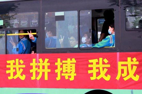 2023年6月7日，在湖北省十堰市郧阳区一中考点，考生向车窗外打手势。  中新社记者曹忠宏摄
