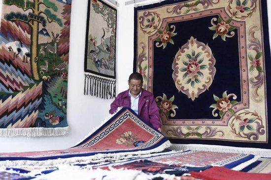 在西宁市湟中县上新庄镇加牙村，杨永良在整理制作好的藏毯。 新华社记者 张龙 摄