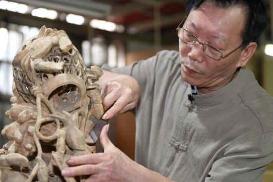 国家级非遗项目潮州木雕省级传承人金子松在雕刻中。新华社记者 卢汉欣 摄