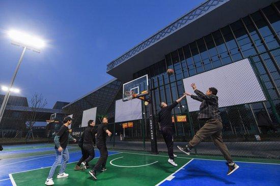 村民们在浙江省湖州市吴兴区织里镇文体中心的灯光球场打篮球（2022年1月18日摄）。新华社记者 徐昱 摄