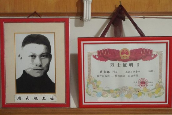  5月24日拍摄的周大根烈士遗像和烈士证明书。新华每日电讯记者张梦洁摄