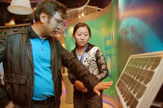 游人在中国锗工业博物馆了解锗在太阳能电池上的应用图：新华社资料