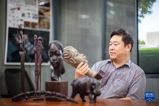 9月12日,在武汉中南建筑设计院总部,唐文胜介绍他收藏的非洲木雕作品。新华社记者 伍志尊 摄