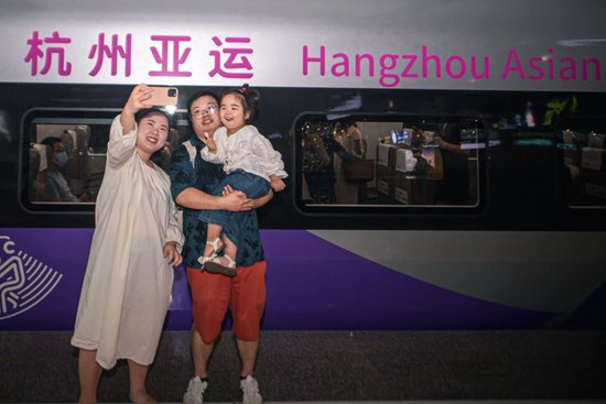 9月16日，在杭州东站站台，乘客与复兴号亚运智能动车组列车合影留念。 新华社记者 江汉 摄