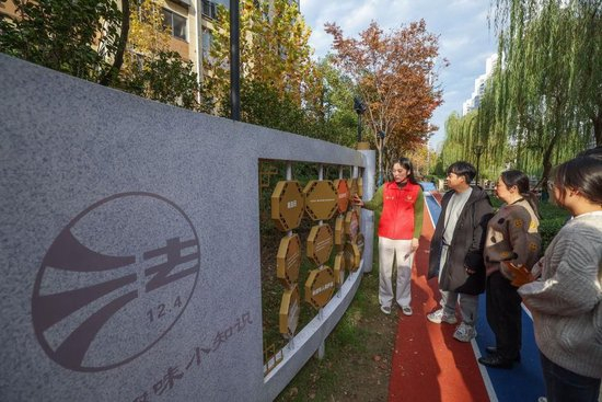 △2023年11月22日，浙江湖州龙泉街道祥和社区工作者在环河健康步道旁为居民进行普法宣传。