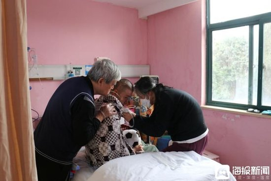 采访过程中张昌硕突然咯痰，张宏银和郑建英为他整理&nbsp;