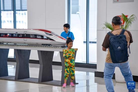 1月24日，在印度尼西亚雅加达哈利姆站候车大厅，一名小朋友和雅万高铁高速动车组模型合影 图：新华社