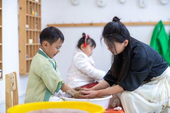 2024年4月2日，江苏泰州，兴化市文峰幼儿园，老师和小朋友一起做陶艺。（人民视觉/图）