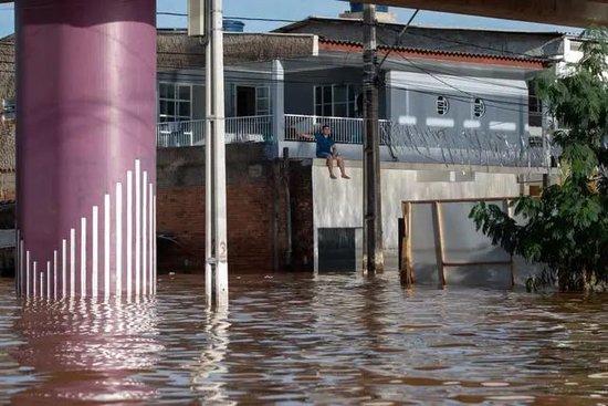  5月7日，在巴西南里奥格兰德州圣莱奥波尔多，一名男子在被洪水浸泡的建筑物上休息。图片来源：新华社发（克劳迪娅·马尔提尼摄）
