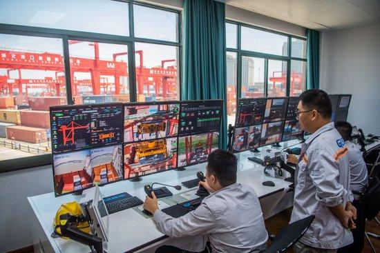  2023年7月5日，湖北武汉阳逻港工作人员远程操作机械设备吊装集装箱。