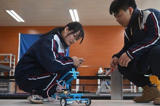 △青海果洛西宁民族中学学生操作自己组装的机器人。