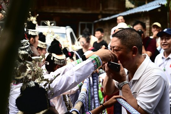 客人听完拦路歌后饮酒入寨