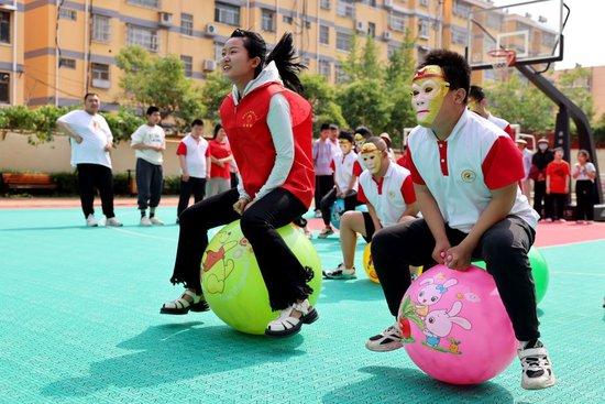 2024年5月17日，在山东省枣庄市市中区特殊教育中心，青年志愿者与智力障碍学生一起做游戏。新华社发（孙中喆摄）