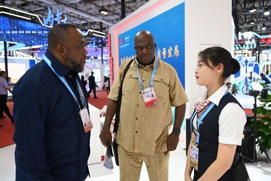 在福建厦门举行的第二十四届中国国际投资贸易洽谈会上，中国银行员工（右）向加纳客商介绍中国银行全球机构分布及跨境金融服务（2024年9月8日摄）。新华社记者 林善传 摄