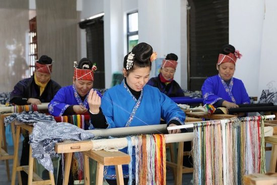  2024年12月16日，在贵州省黔东南苗族侗族自治州施秉县城关镇易地扶贫搬迁南官营社区一家苗绣企业生产车间，入职的社区居民在赶制订单产品。新华社发（邰胜智摄）