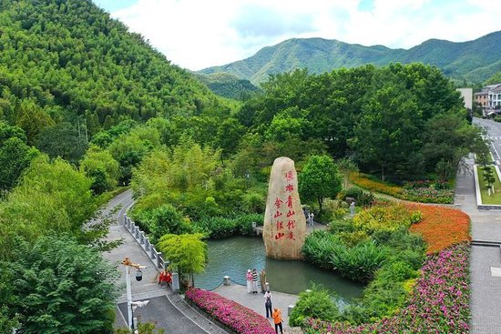  2025年8月6日，在浙江省湖州市安吉县余村，游客在刻有“绿水青山就是金山银山”的石碑前留影（无人机照片）。新华社记者 毛竹 摄