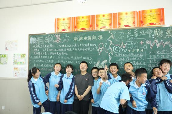  周思武（左四）支教时与孩子们在一起合影（央广网发 天津美术学院供图）