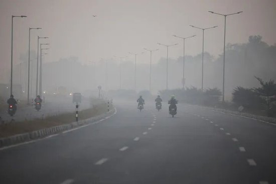 ▲11月25日，在印度新德里，寻求学中人们在雾霾天气里骑摩托。印度印媒（新华社）