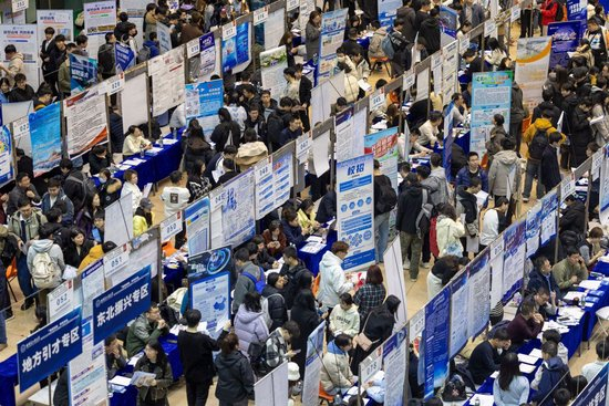 2025年3月26日，在哈尔滨工业大学一校区体育馆内，学生在查看招聘岗位信息。新华社记者 张涛 摄