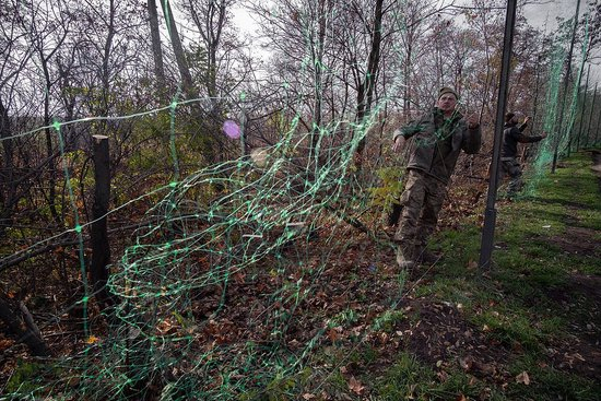 11月4日，顿涅茨克地区，乌克兰士兵在道路沿线安装反无人机网。（视觉中国）