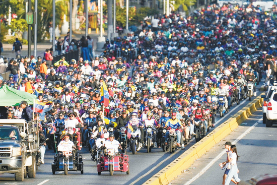 当地时间22日，委内瑞拉民众在首都加拉加斯骑着摩托车抗议美国的干涉。（视觉中国）