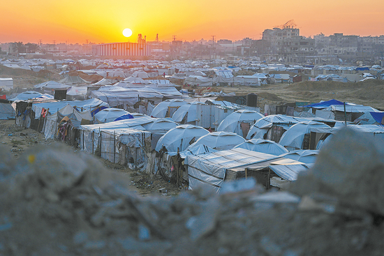 　　當(dāng)?shù)貢r(shí)間12月24日，加沙地帶中部布賴杰難民營(yíng)，夕陽(yáng)下的臨時(shí)帳篷營(yíng)地，流離失所的巴勒斯坦人在此安家。（視覺(jué)中國(guó)）