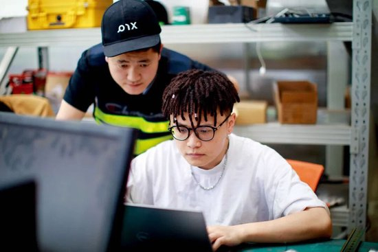 在贵阳市高新区生态科技产业园一家无人驾驶汽车企业内，毕业于美国爱荷华州立大学人机交互专业的肖宇晗（右）在电脑上进行软件调试。图/新华