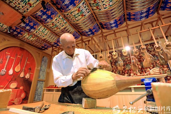 2026年1月3日，村民在托万克吾库萨克村民族乐器手工坊内打磨乐器。米尔阿迪力江·麦麦提吐尔逊摄