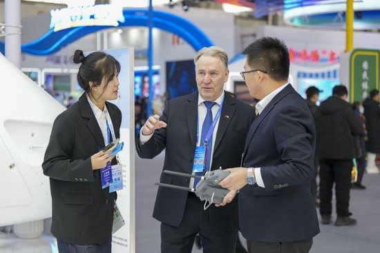 1月6日，在2026哈尔滨国际冰雪经济博览会现场，参会嘉宾（中）在了解一款工业无人机的参数和性能。新华社记者 王松 摄