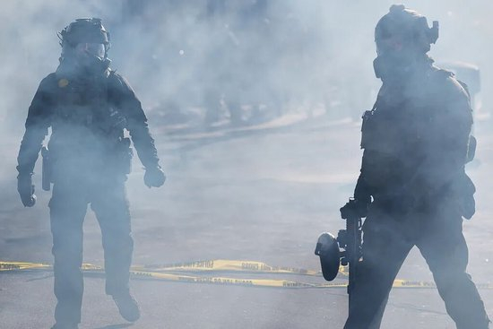  当地时间2026年1月24日，美国明尼阿波利斯，移民执法人员施放催泪瓦斯。图/视觉中国