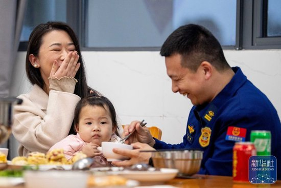  ↑ 2月16日，在江苏省泰兴市澄江西路消防救援站，消防员和家属一起吃团圆饭。新华社发（杨玉岗 摄）