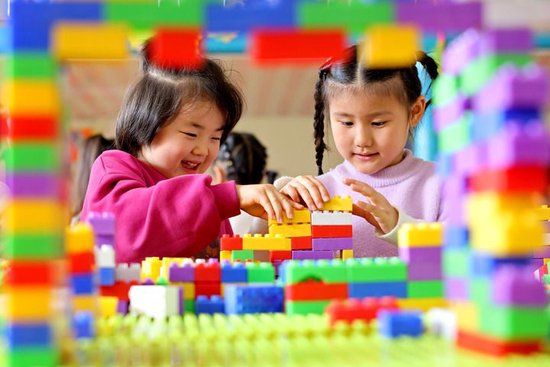 2025年11月6日，在山东省枣庄市市中区西王庄镇中心幼儿园，托育班的小朋友在拼搭积木。新华社发（孙中喆 摄）