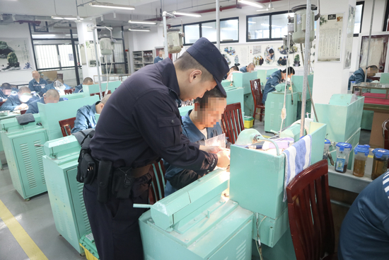 　在上海青浦监狱，民警倪力立指导罪犯开展玉石雕刻艺术矫治（图/受访者提供）