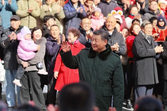 △2026年2月10日，习近平总书记在北京东城区隆福寺街区考察时，向现场群众挥手致意。