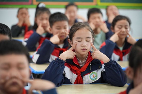 图为陕西安康市平利县老县镇中心小学学生在教室内做眼保健操。新华社记者 邵瑞 摄