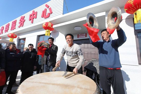 2025年1月28日，辽宁省葫芦岛市绥中县明水满族乡祝家沟村村民在重建新房的村党群服务中心前鸣锣击鼓。新华社发（田嘉摄）
