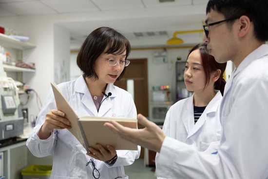 陈玲玲（左一）在中国科学院分子细胞科学卓越创新中心实验室和学生们交流（2022年8月11日摄）。新华社记者 金立旺 摄
